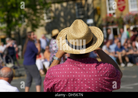 Rückseite des ein Mann trägt einen Strohhut und ein Foto auf eine Menge von Menschen. Stockfoto