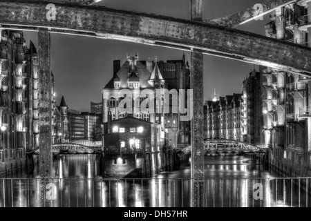 Blick durch die Poggenmuehlenbruecke Brücke in Richtung Wasserschloesschen Wasserburg in der Nacht, Speicherstadt, Hamburg, Hamburg Stockfoto