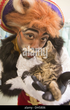 Puss in Boots Panto Charakter spielt mit Kätzchen in die Zucht von Battersea Hunde & Katzen zuhause, Xmas Panto im Hackney Empire Stockfoto