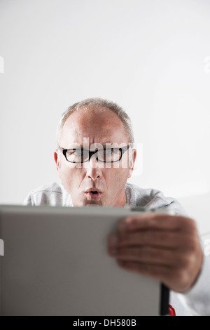 Mann mit einem Tablet PC mit einem betäubt Ausdruck, Mannheim, Baden-Württemberg, Deutschland Stockfoto