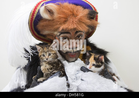 Puss in Boots Panto Charakter spielt mit Kätzchen in die Zucht von Battersea Hunde & Katzen zuhause, Xmas Panto im Hackney Empire Stockfoto