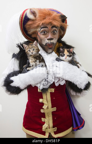 Puss in Boots Panto Charakter spielt mit Kätzchen in die Zucht von Battersea Hunde & Katzen zuhause, Xmas Panto im Hackney Empire Stockfoto