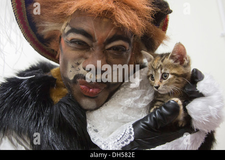 Puss in Boots Panto Charakter spielt mit Kätzchen in die Zucht von Battersea Hunde & Katzen zuhause, Xmas Panto im Hackney Empire Stockfoto