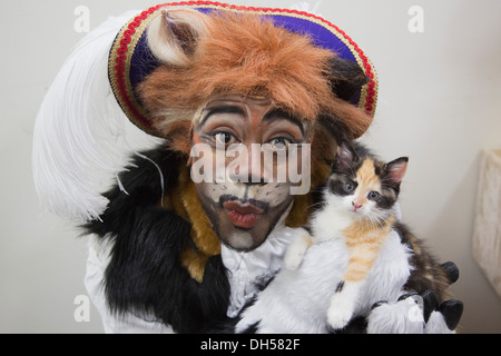 Puss in Boots Panto Charakter spielt mit Kätzchen in die Zucht von Battersea Hunde & Katzen zuhause, Xmas Panto im Hackney Empire Stockfoto