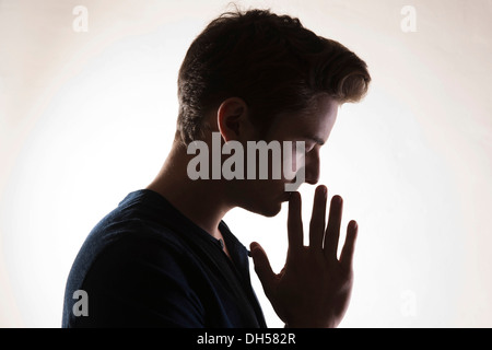Nachdenklicher junger Mann, Hintergrundbeleuchtung, Mannheim, Baden-Württemberg, Deutschland Stockfoto