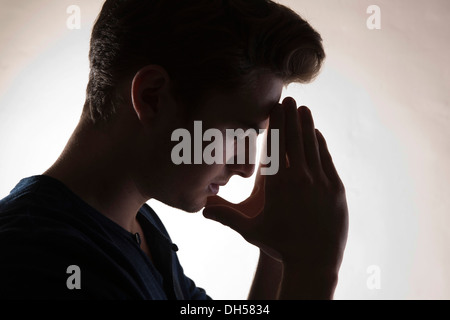 Nachdenklicher junger Mann, Hintergrundbeleuchtung, Mannheim, Baden-Württemberg, Deutschland Stockfoto