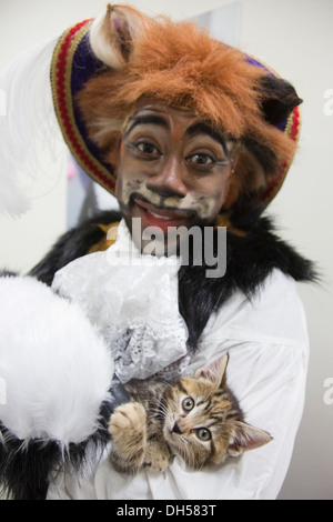 Puss in Boots Panto Charakter spielt mit Kätzchen in die Zucht von Battersea Hunde & Katzen zuhause, Xmas Panto im Hackney Empire Stockfoto