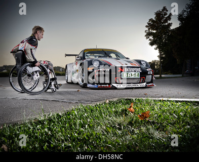 Rennfahrer in einem Rollstuhl, neben seinen Porsche-Rennwagen, München, Upper Bavaria, Bavaria, Germany Stockfoto