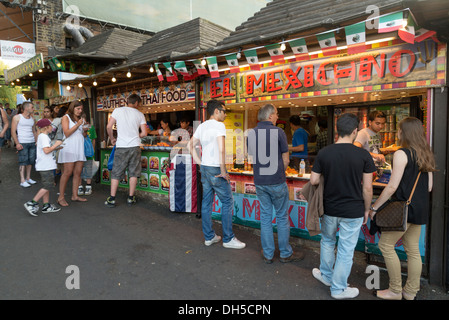 Menschen Essen zum mitnehmen auf Moped-Stil-Sitze in Camden Market, London, England, UK Stockfoto