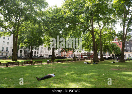 Büroangestellte, die sich in Berkeley Square Gardens, Mayfair, London, Großbritannien, ausruhen Stockfoto