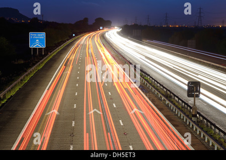 Langzeitbelichtung Abend Verkehr auf Autobahn M56 halten zwei Chevrons auseinander Anzeichen UK Stockfoto