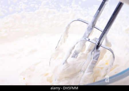 Schlagobers (Sahne) geschlagen mit einem Schneebesen in einer Glasschale Stockfoto