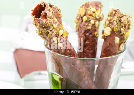 Brandy Snaps eingetaucht in Schokolade und Pistazien Stockfoto