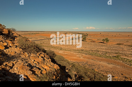 Weite karge australischen outback-Landschaft mit Weg schneiden über baumlose Prärie Dehnung zu fernen Horizont im westlichen Queensland während der Dürre Stockfoto