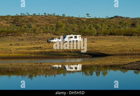 Weiße Wohnwagen und Auto / vier Fahrzeug geparkt auf grasbewachsenen Hügel spiegelt sich im blauen Wasser - See Corella outback Queensland Stockfoto