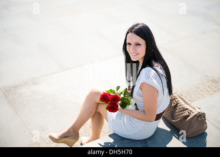 Glückliche Frau mit roten Rosen - außerhalb Lifestyle portrait Stockfoto