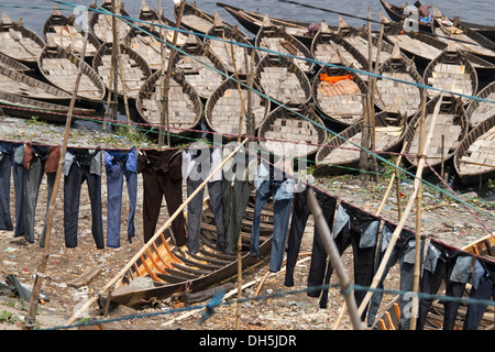 Jeans hängen zum Trocknen an Wäscheleinen vor Boote am Ufer des Flusses Buriganga, Dhaka, Bangladesch, Südasien, Asien Stockfoto