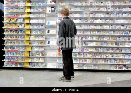 Ten-Year-Old Boy Boy in einem Geschäft mit einer großen Auswahl an Nintendo DS-Spiele Stockfoto