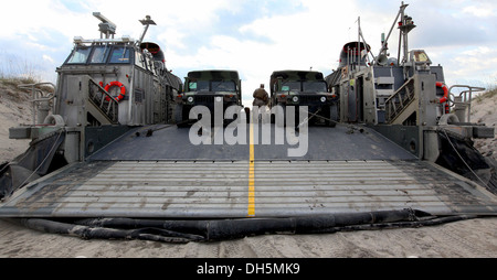 Zwei US Marine Corps Humvees sind auf dem Deck eines US Navy Landing craft, Luftpolster bei einer Bewegung des 2 geschnallt. Stockfoto