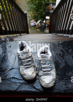 alte Turnschuhe auf der obersten Stufe der Treppe links Stockfoto