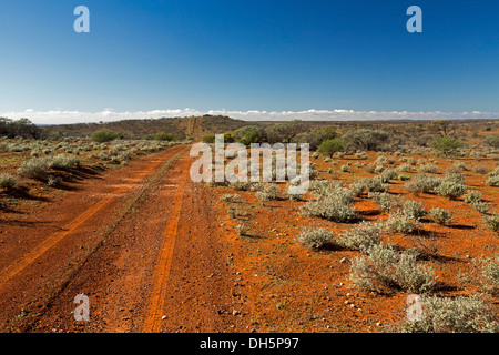 Australische Outback-Landschaft mit langen roten Straße über weiten baumlosen Ebenen der Schaffarm im nördlichen Südaustralien zum fernen Horizont Stockfoto