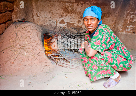 Frau mit blauem Tuch, Berber Frau, so dass ein Feuer in einem Ton Ofen, Südmarokko, Marokko, Afrika Stockfoto