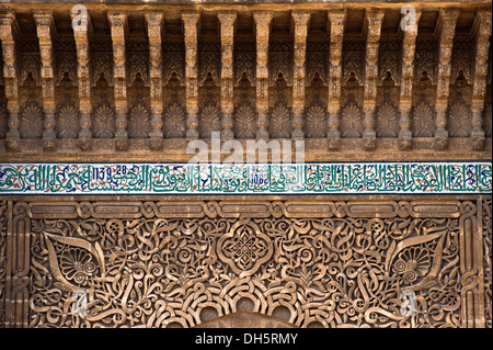 Stuck-Verzierungen und Fliesen-Mosaike mit koranischen Verse über das Tor, das Mausoleum und die Moschee Moulay Ismail, Meknès, Marokko Stockfoto