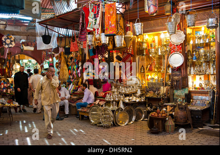 Menschen zu Fuß Vergangenheit Geschäfte verkaufen Messing Güter und Stoffe in einer Gasse in den Souks, Bazar, Marrakesch, Marokko, Afrika Stockfoto