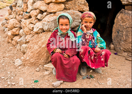 Zwei Mädchen mit Kopftuch, Nomadenkinder, Berber Leute, vor einem einfachen Stein Wohnung hocken Stockfoto