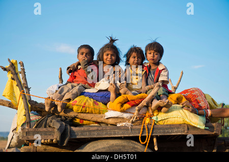 Vier Kinder sitzen auf einem Kamel Wagen, Pushkar Camel Fair, Pushkar, Rajasthan, Indien Stockfoto
