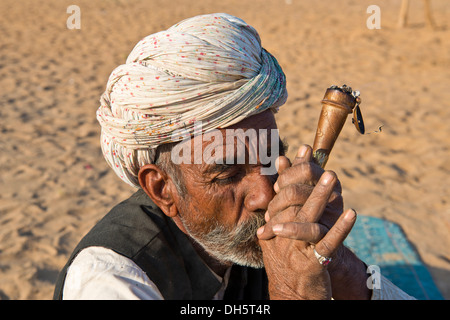 Indischer Mann mit einem Turban raucht eine Pfeife Hash, Pushkar, Rajasthan, Indien Stockfoto