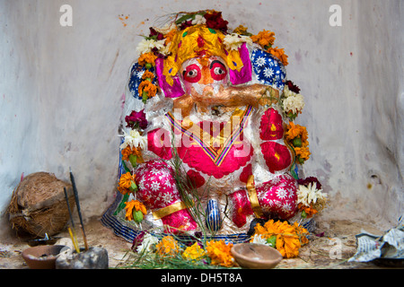 Hindu-Tempel Schrein mit einem bunt bemalten Ganesha Statue und Angebote, Jodhpur, Rajasthan, Indien Stockfoto