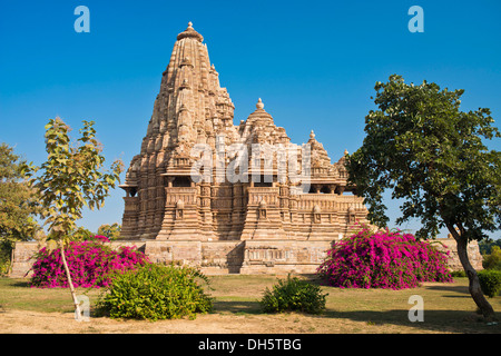 Hindu-Tempel mit blühenden Bougainvillea Büsche, Kandariya Mahadeva Tempel, Western Group, Khajuraho Gruppe von Denkmälern Stockfoto