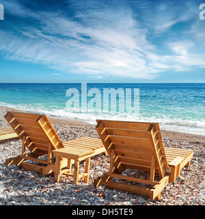 Zwei hölzerne Liegestühle stehen am Strand in Montenegro Stockfoto