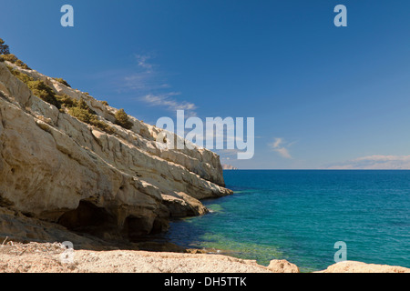 Ein türkisblaues Meer und beeindruckende Formationen aus Sandsteinfelsen in Matala, gelegen an der Bucht der Messara-Ebene, Kreta, Griechenland. Stockfoto