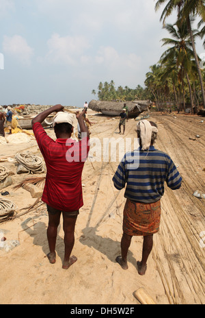 Gruppe von Fischern sortieren ihre Netze auf den Strand, Varkala, Kerala, Indien, Asien Stockfoto