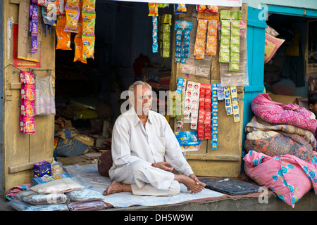 Leitenden indischen Mann sitzt auf einer Decke vor seinem Stall, Jodhpur, Rajasthan, Indien Stockfoto