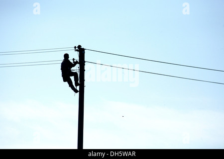 Man arbeitet an einem Strommast Stockfoto