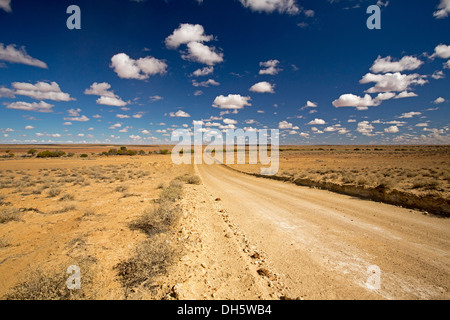 Landschaft mit langen Schotterstraße erstreckt sich über die weiten Ebenen des australischen Outback in der Nähe von Lake Eyre in Nord-Süd-Australien Stockfoto