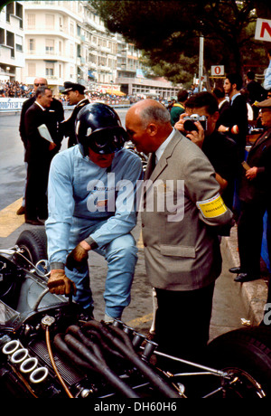 Graham Hill mit seinem BRM P261 spricht mit Ingenieur Vic Barlow von Dunlop bei in den Gruben. Grand Prix von Monaco 30. Mai 1965. Stockfoto