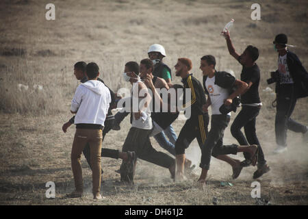 Gaza, Palästinensische Gebiete. 1. November 2013. Palästinenser tragen einen verletzten Demonstranten nach israelische Truppen Tränengas Kanister an der Kreuzung von Nahal Oz mit Israel, östlich von Gaza-Stadt, am 1. November 2013 feuerte. Israelische Truppen am Freitag stießen Palästinenser während der Demonstrationen im Osten, Jerusalem, das Westjordanland und Gaza-Streifen Jahrestag der Balfour-Deklaration, die den jüdischen Staat in Palästina gewährt. Bildnachweis: Moemen Faiz/NurPhoto/ZUMAPRESS.com/Alamy Live-Nachrichten Stockfoto