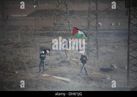 Gaza, Palästinensische Gebiete. 1. November 2013. Ein palästinensischer Demonstrant hält Palästina Flagge während der Auseinandersetzungen nach einem Protest am Grenzübergang Nahal Oz mit Israel, östlich von Gaza-Stadt, am 1. November 2013. Israelische Truppen am Freitag stießen Palästinenser während der Demonstrationen im Osten, Jerusalem, das Westjordanland und Gaza-Streifen Jahrestag der Balfour-Deklaration, die den jüdischen Staat in Palästina gewährt. Bildnachweis: Moemen Faiz/NurPhoto/ZUMAPRESS.com/Alamy Live-Nachrichten Stockfoto