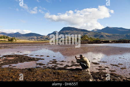 Ein Mann fotografiert am Ufer des oberen Loch Torridon Torridon Dorf im westlichen Schottland, Großbritannien Stockfoto