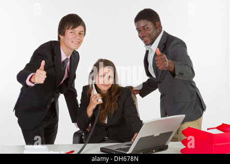 Junge Geschäftsleute in einem Büro, Männer machen eine Daumen-hoch-Geste Stockfoto