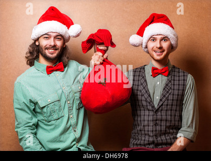 Zwei Hipster in Santa Claus Kleidung mit der Tasche der Geschenke Stockfoto