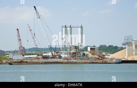 Eine industrielle Kieswerk. Lagerung von Sand und Kies, mit Förderbändern in einer industriellen Umgebung durch einen Hafen. Stockfoto