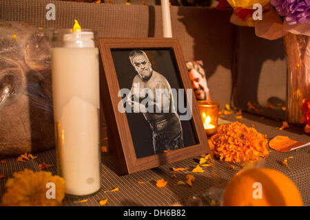 New York, NY, 31. Oktober 2013. Kerzen und ein Foto eines Mannes in ein Ringer Gewand stehen auf dem öffentlichen Altar im Gedenken an die Verstorbenen. Der Altar hält auch traditionelle orange Ringelblumen und ein Angebot oder Ofrenda, Brot, gesehen auf der linken Seite, verpackt in Kunststoff. Bildnachweis: Ed Lefkowicz/Alamy Live-Nachrichten Stockfoto