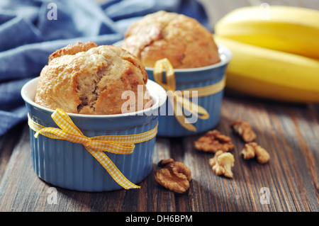 Bananen-Muffins in Backform mit Nüssen über hölzerne Hintergrund Stockfoto