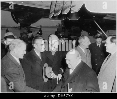 Der britische Premierminister Winston Churchill wird auf einem Flughafen in Washington, D.C. gezeigt, wo er von US-Beamten begrüßt wird. Der Besuch war ein wichtiger Moment in den Beziehungen zwischen den USA und Großbritannien während des Zweiten Weltkriegs Stockfoto