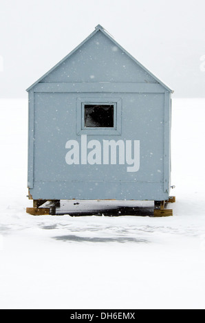Eine kleine blaue Eis Angeln Hütte in einem Schneesturm. Stockfoto